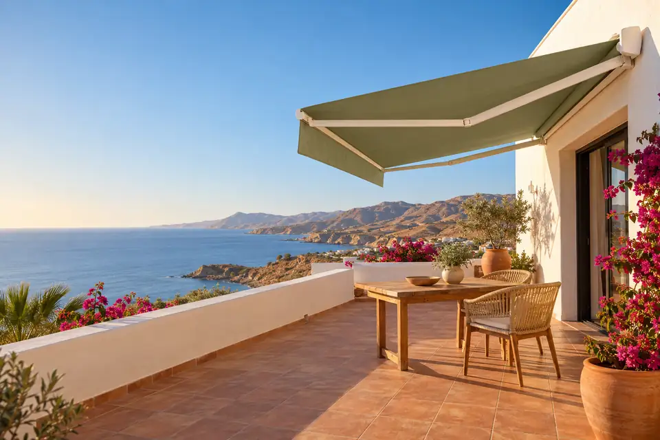 Toldo de lona lisa verde salvia sobre una terraza con vistas al mar